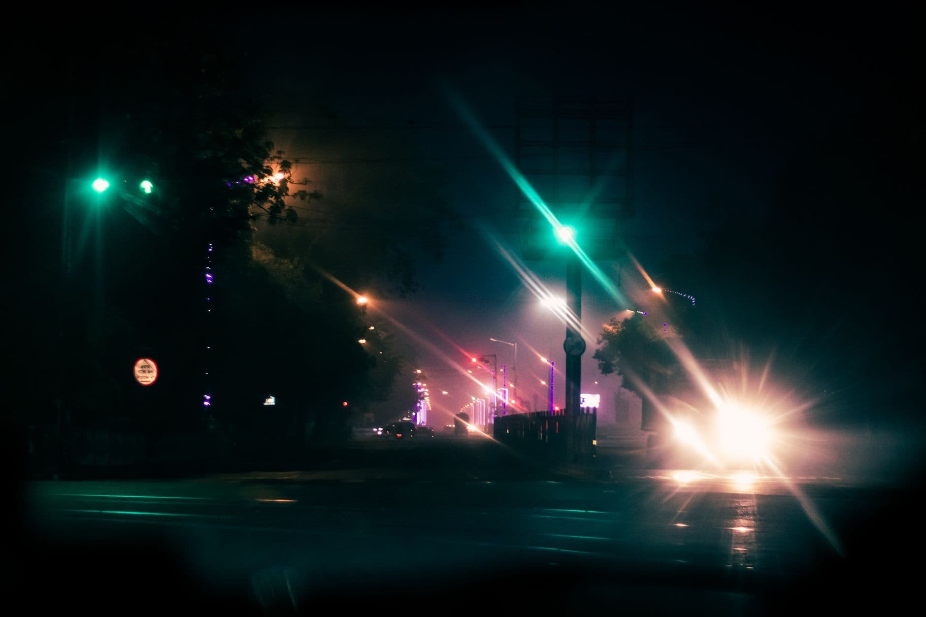 Rue de nuit sous la pluie, feux de signalisation au vert